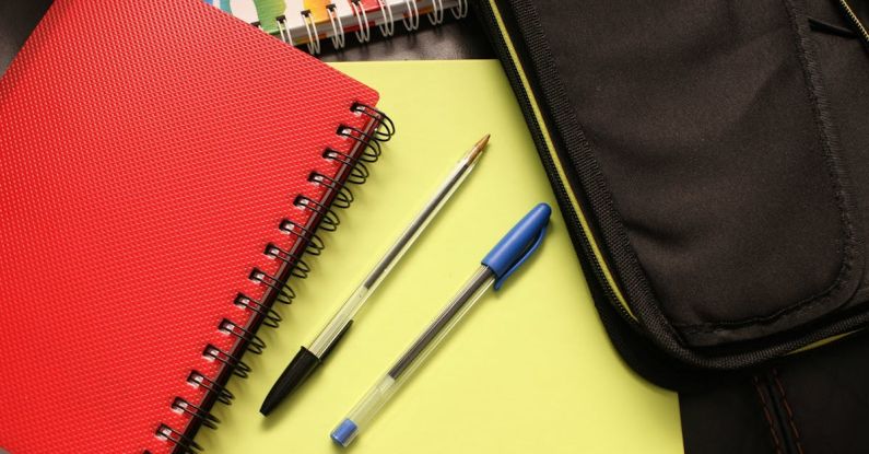 Binders - Black and Blue Pens Beside Red Covered Notebook